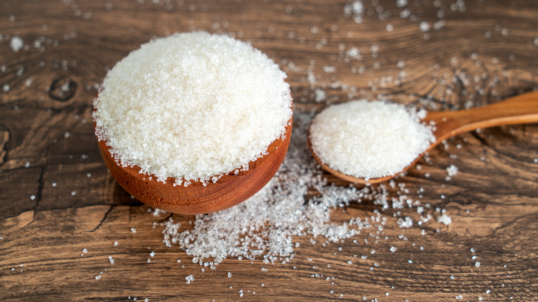 a bowl of granulated sugar with a wooden spoon holding some