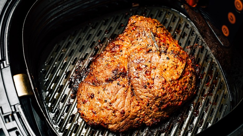 Beef steak sitting in an air fryer basket