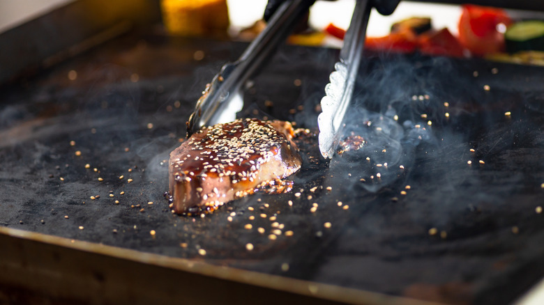 steak covered in sauce on griddle