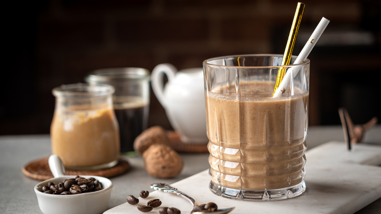 a glass with a peanut butter drink and straw