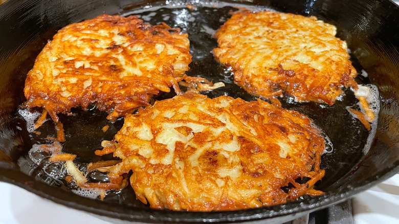 potato latkes frying in a pan
