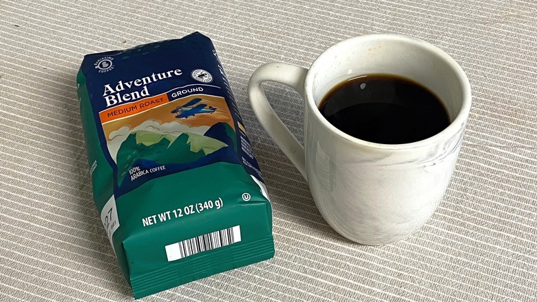 Adventure Blend coffee in bag with a full cup