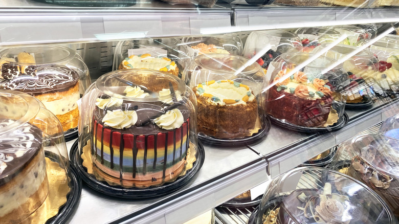 Line of cakes in a grocery store bakery display window
