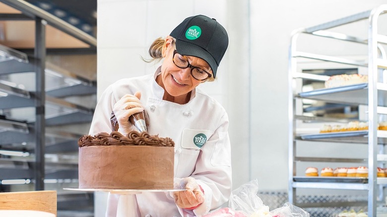 Whole Foods baker decorating chocolate cake