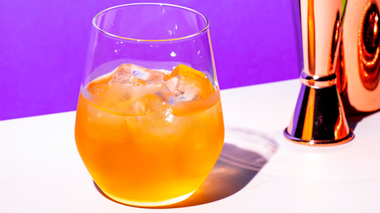 orange juice and gin cocktail with bar implements