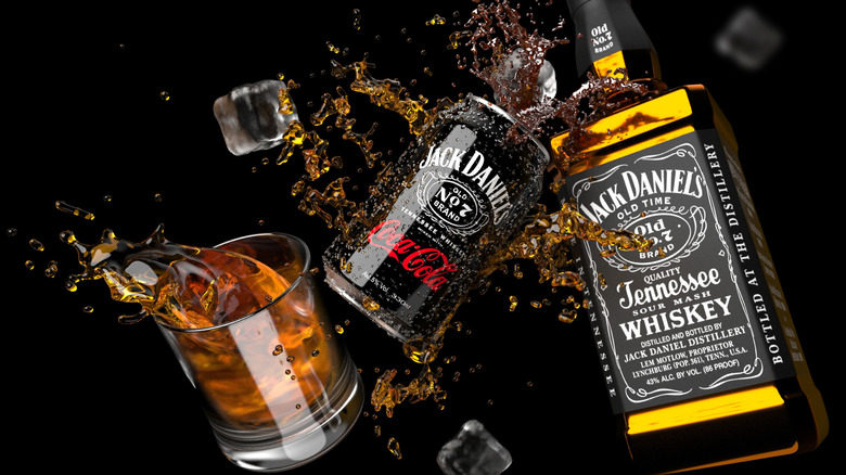 bottle of Jack Daniel's whiskey, can of Jack and Coca-Cola, and a glass