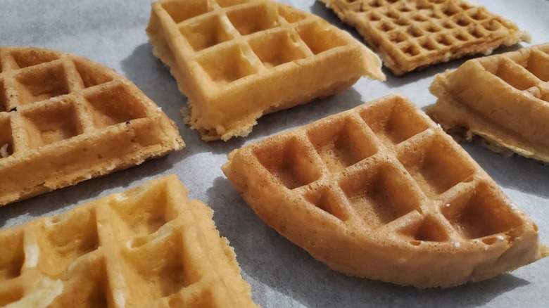 Quartered sections of different waffles on a grey table