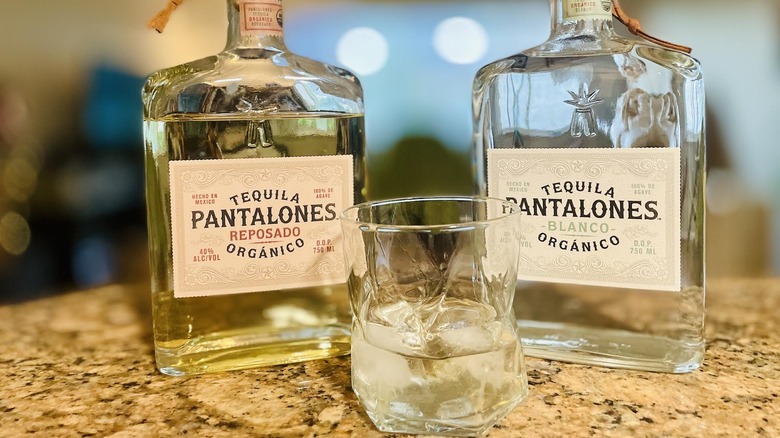 Bottles of Pantalones Reposado and Blanco Tequilas with a pour over ice