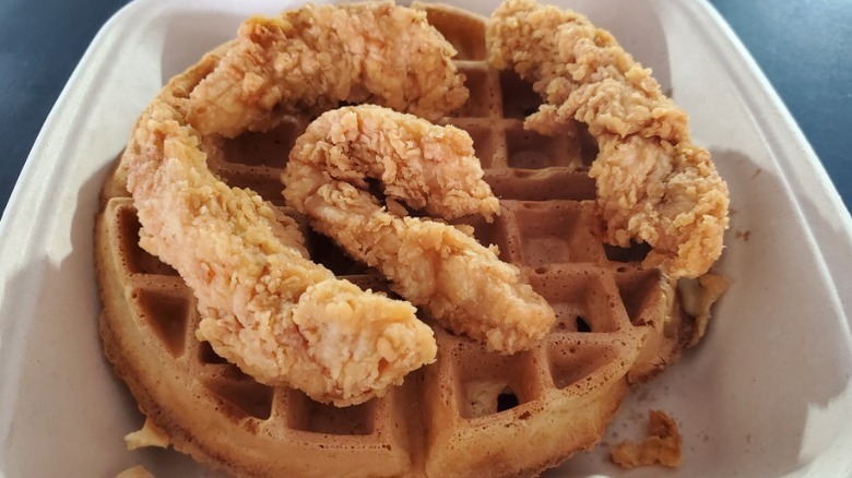 Chicken and waffles from Another Broken Egg Cafe in a white takeout container.