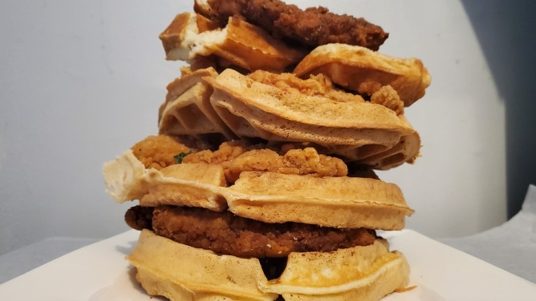 A stack of chicken and waffles from several different restaurants.