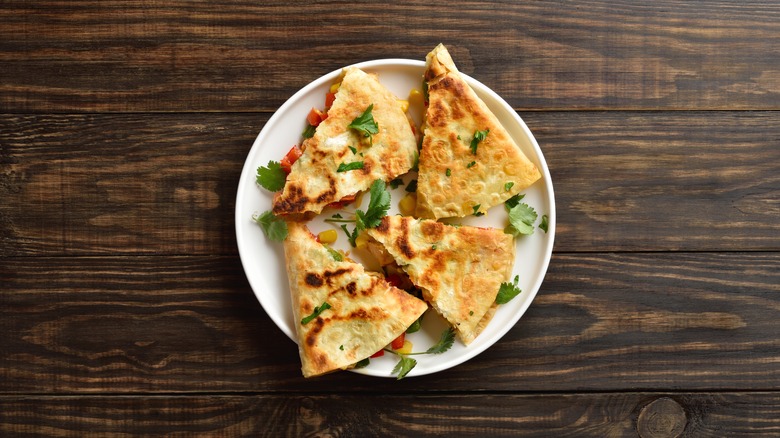 4 slices of quesadilla arranged on a white plate