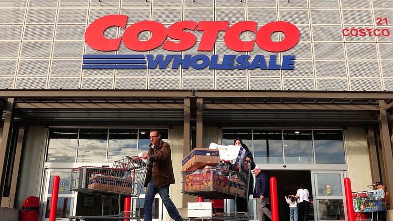 Shoppers pushing full carts outside of Costco Wholesale