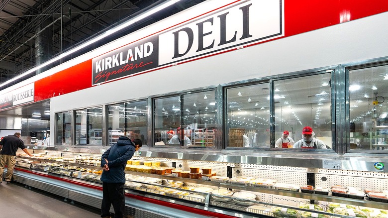 Customers perusing the prepared foods in the deli department inside Costco