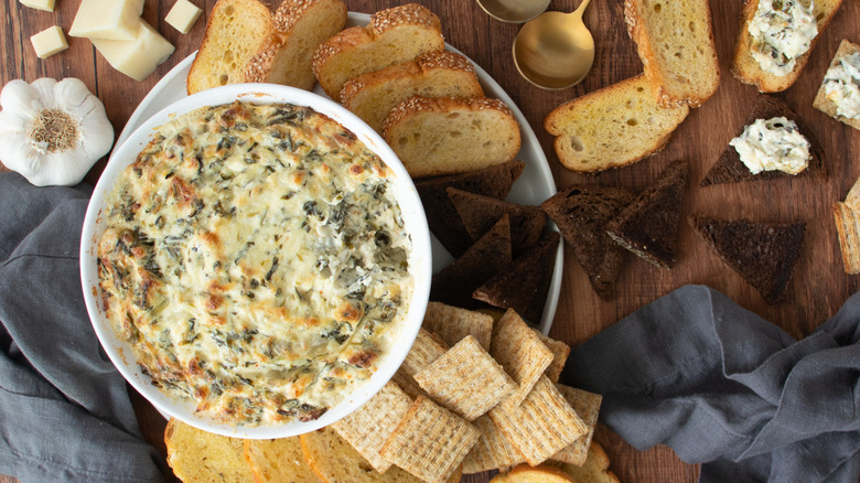 Spinach artichoke dip surrounded by crackers