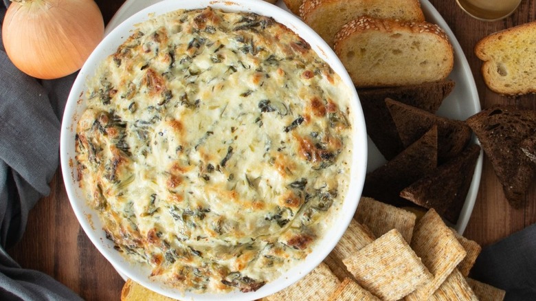Spinach artichoke dip surrounded by crackers