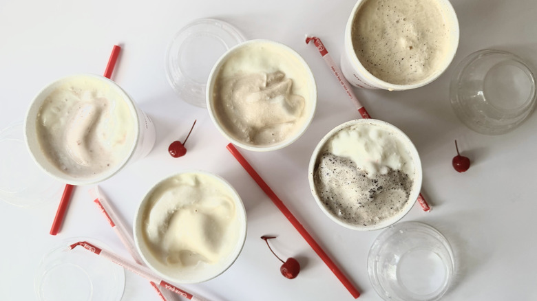 Chick-fil-A Milkshakes half-consumed on a white surface with cherries, straws, and lids