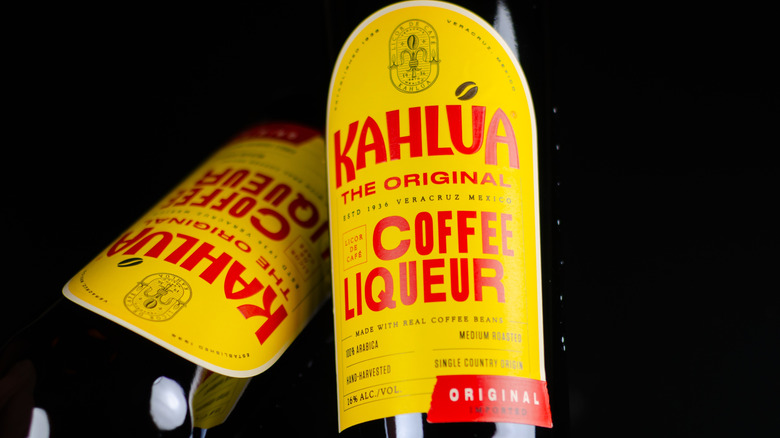 Two bottles of Kahlua original Coffee Liqueur on a black background