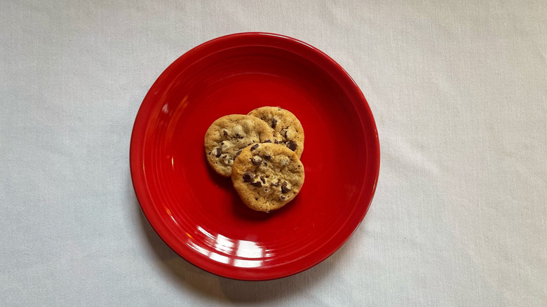 Three mini chocolate chip cookies on a red plate