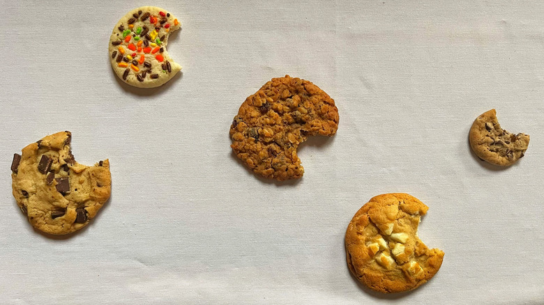 Costco's fiver bakery cookie flavors, each with a bite out of it, arranged on a white background