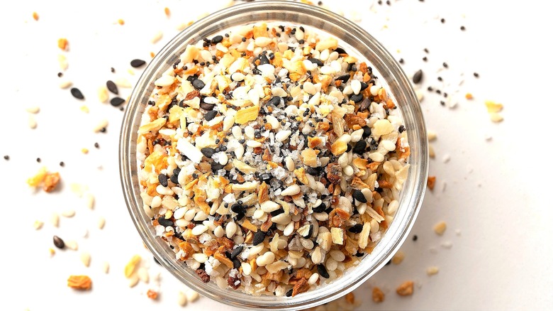 Everything bagel seasoning in a small glass bowl on a white surface