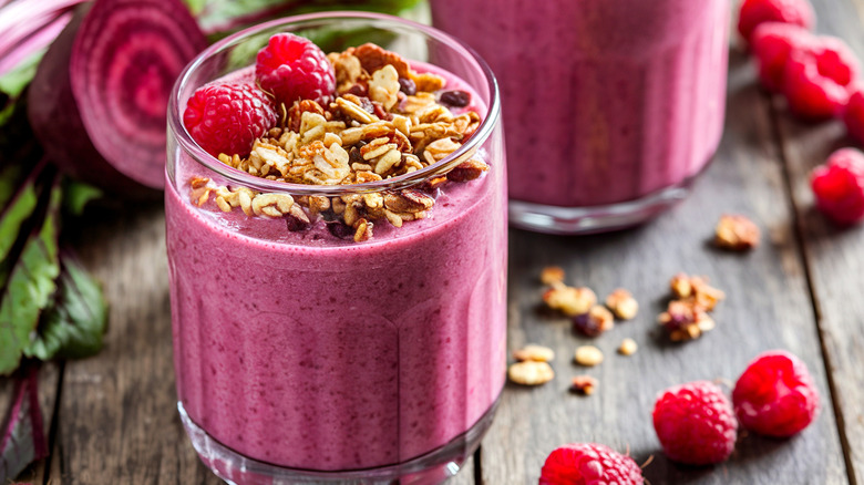 Pink smoothie with granola and raspberries