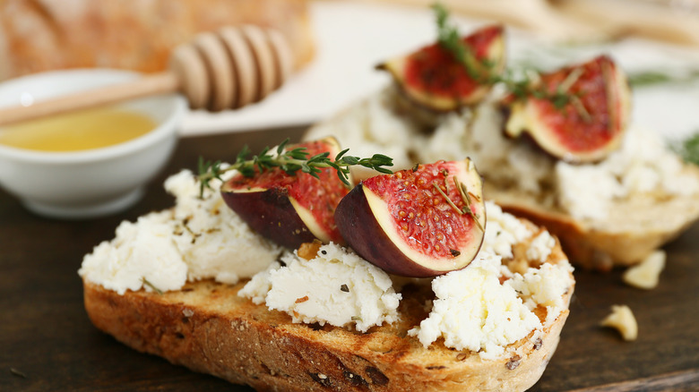 Cheese with figs and herbs on a slice of bread