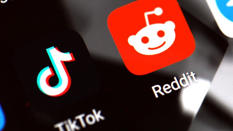 Reddit and TikTok icons on smartphone screen