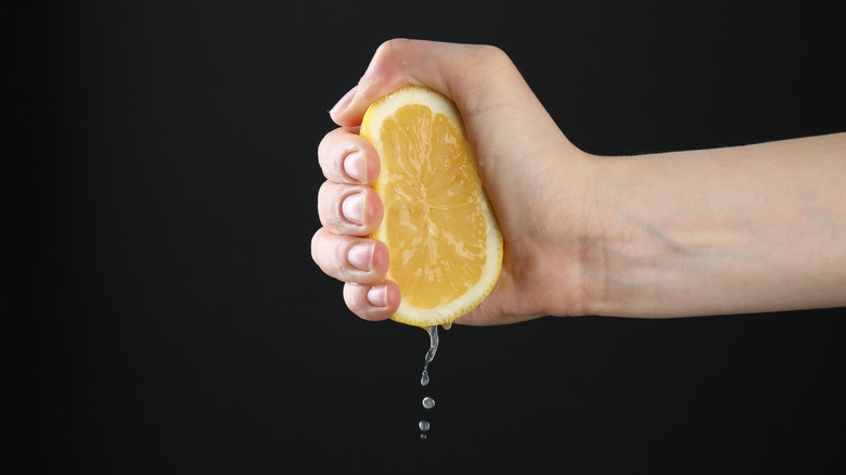 Hand squeezing a lemon
