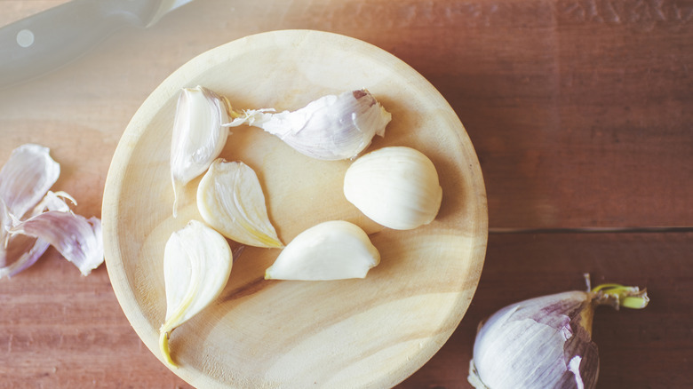 Garlic cloves on wooden plate