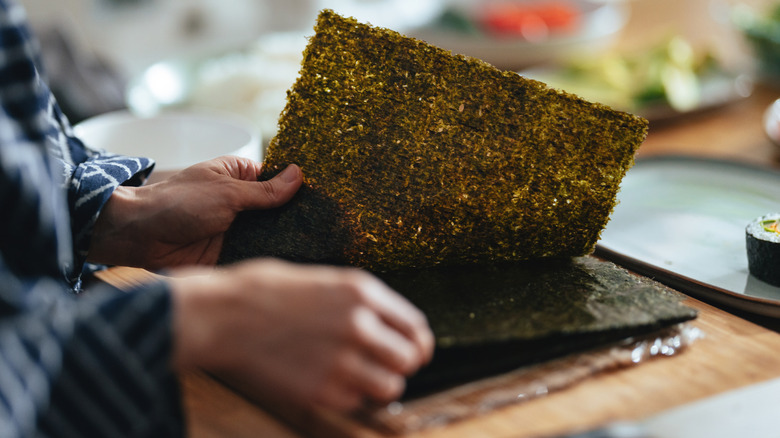 Chef flipping through nori seaweed sheets
