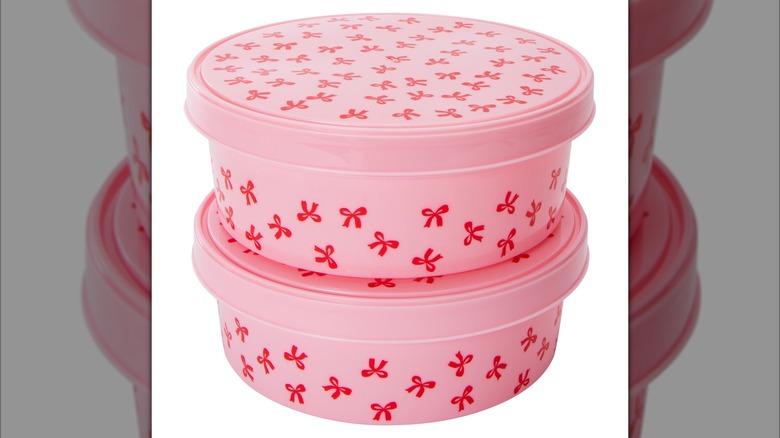 Two pink bowl-type containers with red bows, with one placed on top of the other.