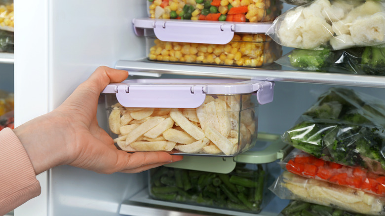 Potatoes stored in an air-tight container being placed in the fridge
