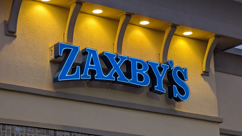 The exterior of a Zaxby's with the logo being illuminated by lights