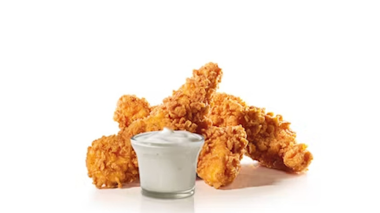 Hardee's chicken tenders and a glass cup of mayonnaise on a white background