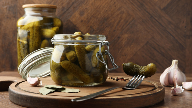 Two glass jars of pickles with fork