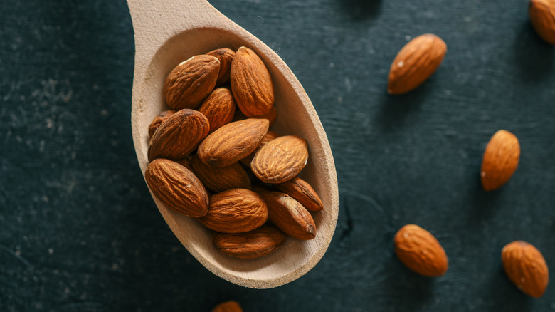 A wooden spoon containing almond nuts