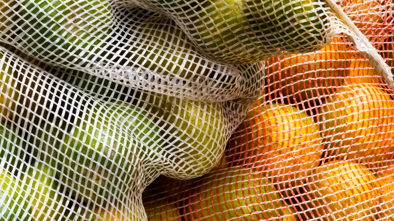 Close up of various vegetables in netted produce bags.