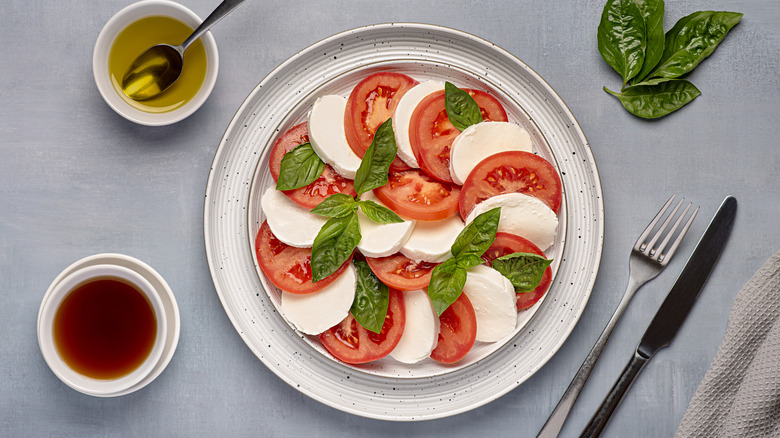 A Caprese salad arranged in a spiral on a plate.