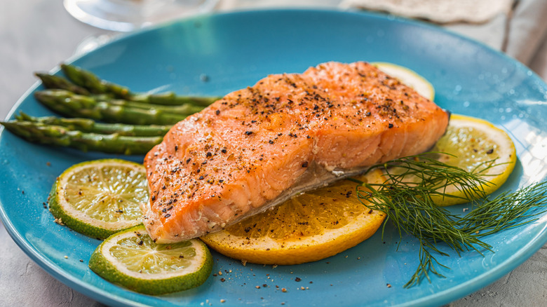 Plated grilled salmon filet on oranges, lemons, and limes