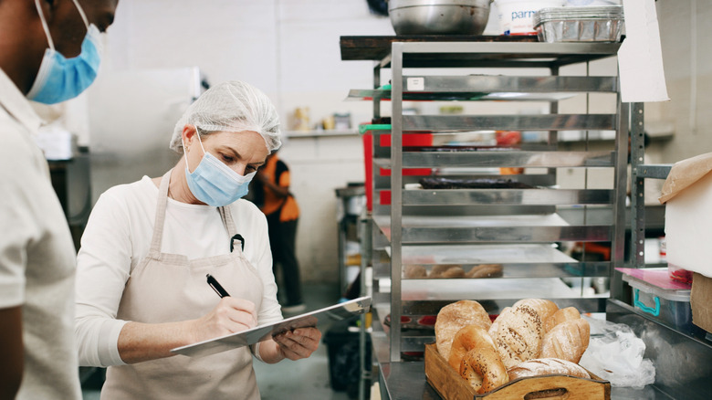 Health inspector with a clipboard in a restaurant kitchen