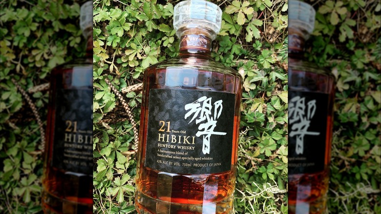 Bottle of Hibiki in front of a bush.