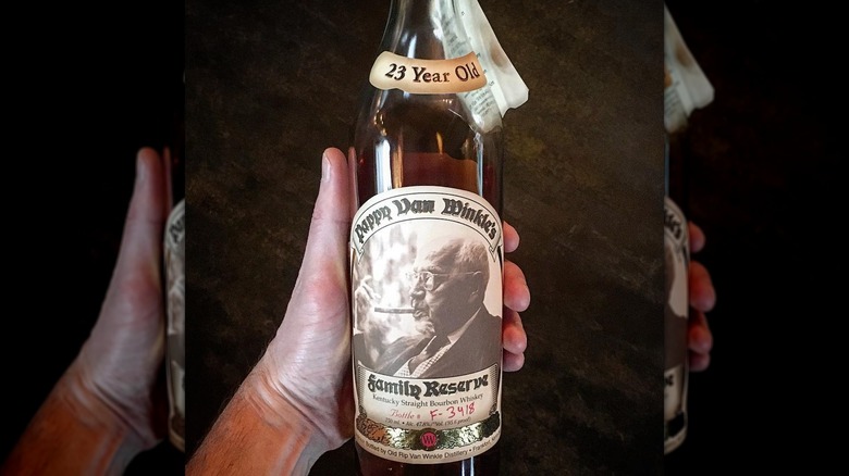 Hand holding a bottle of Pappy Van Winkle