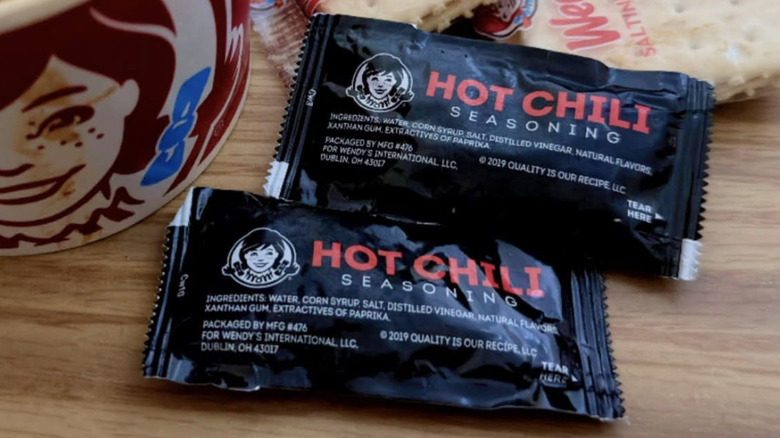 Packets of Wendy's Hot Chili Seasoning on a wood surface