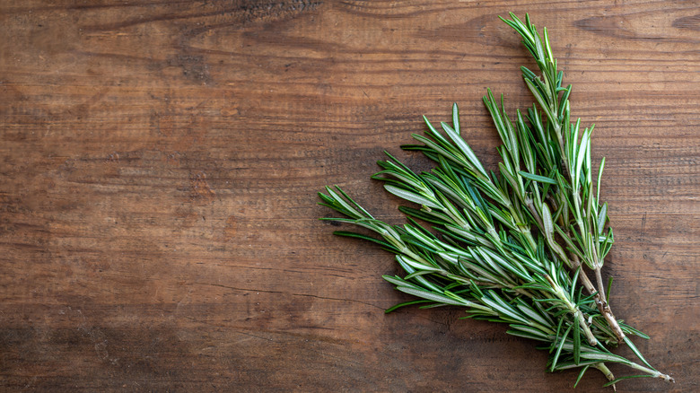 Fresh rosemary sprigs on wooden background