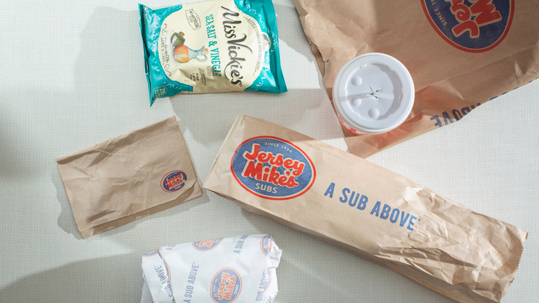 A Jersey Mike's sub with chips and a drink