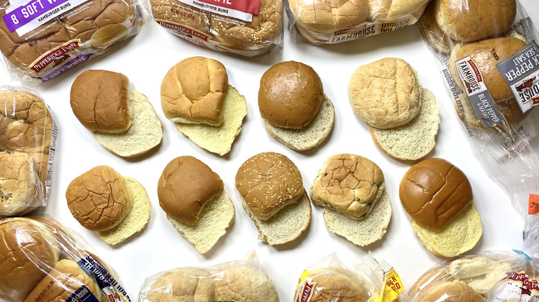 Two rows of Pepperidge Farm hamburger buns surrounded by their packaging on a white surface.