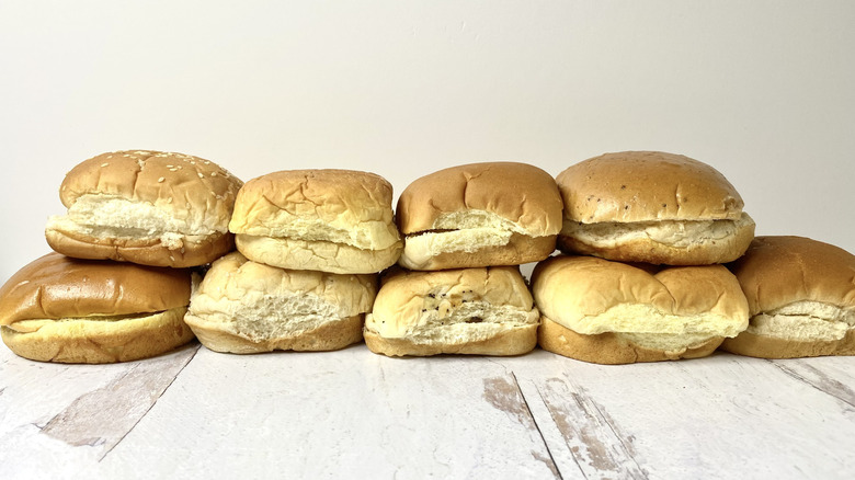 Two rows of stacked hamburger buns on a white surface