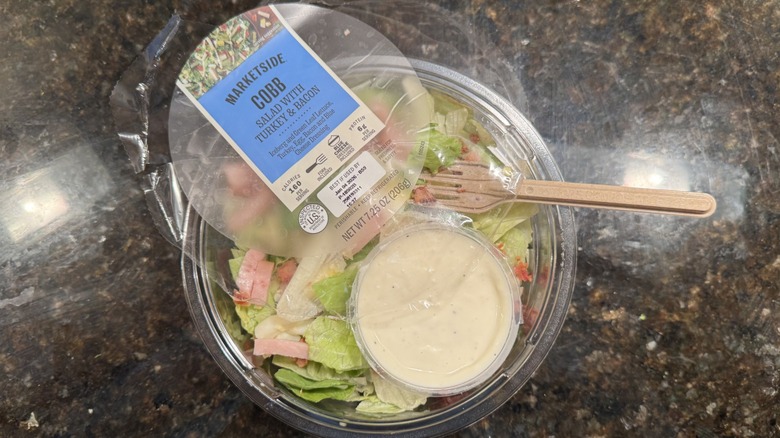 Cobb salad with turkey and bacon on black counter