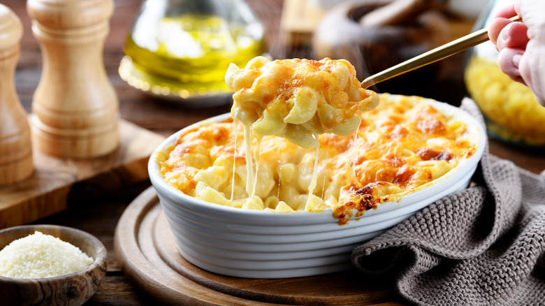 A bowl of macaroni and cheese with a spoonful being lifted out
