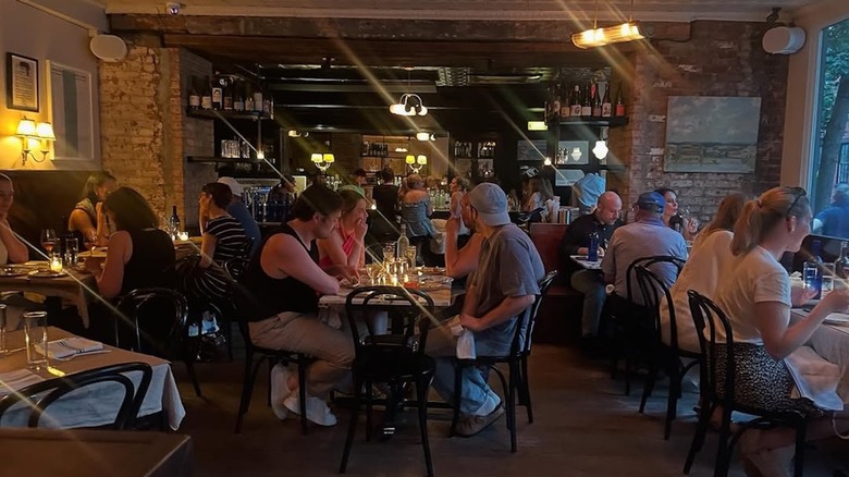 People populate tables in the dimly lit dining room at Ingas Bar.